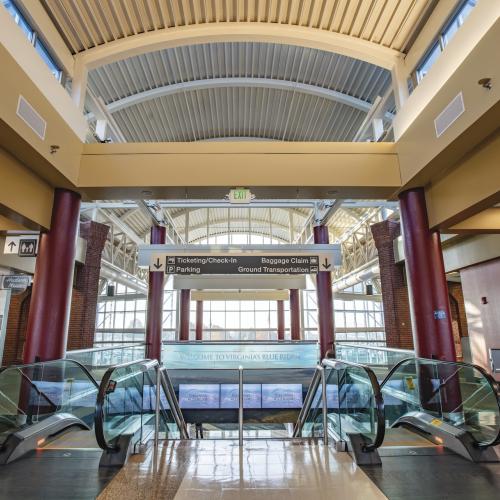 Inside the Roanoke Blacksburg Regional Airport looking at the top of a pair of escalators.